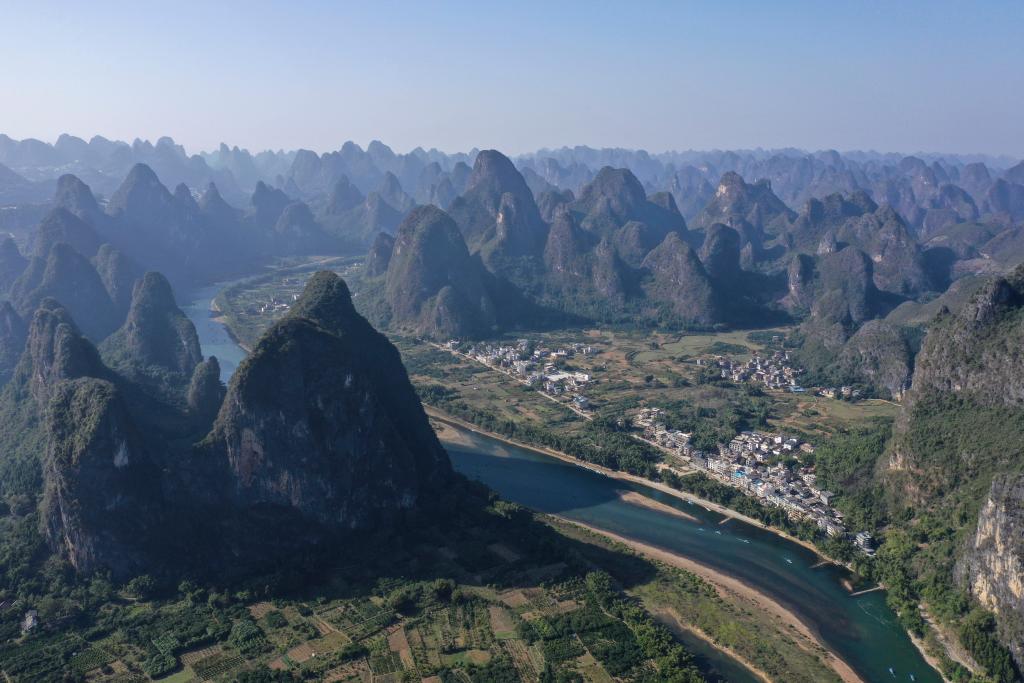 Aerial view of the Li River winding through a forest of karst limestone peaks past the riverside town of Xingping, Guilin