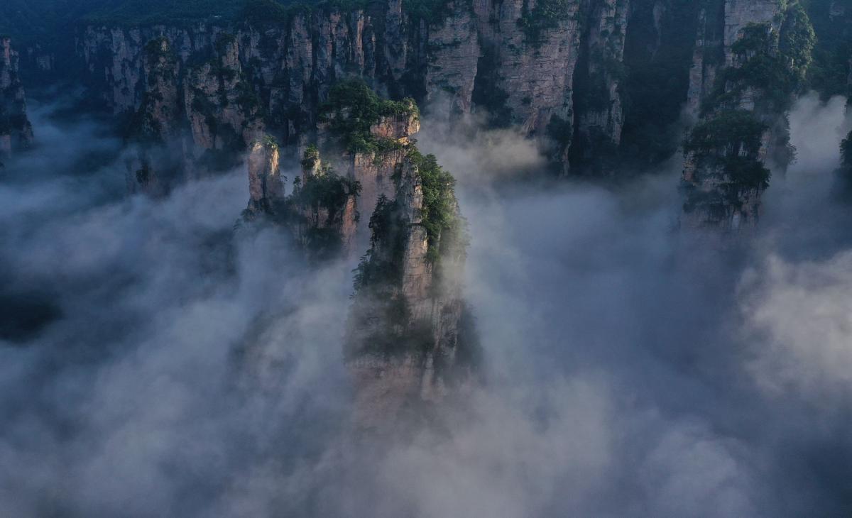 Quartz-sandstone pillars of Wulingyuan in Zhangjiajie rising through a sea of cloud at dawn