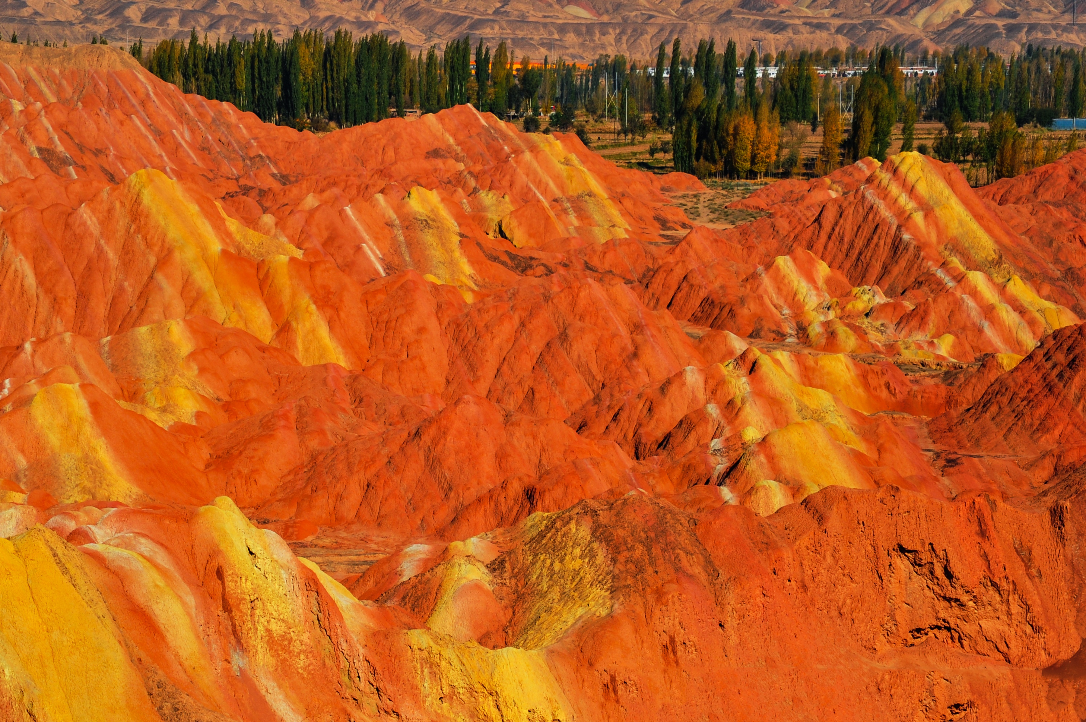 Orange and yellow rock layers of Zhangye Danxia beneath a clear sky